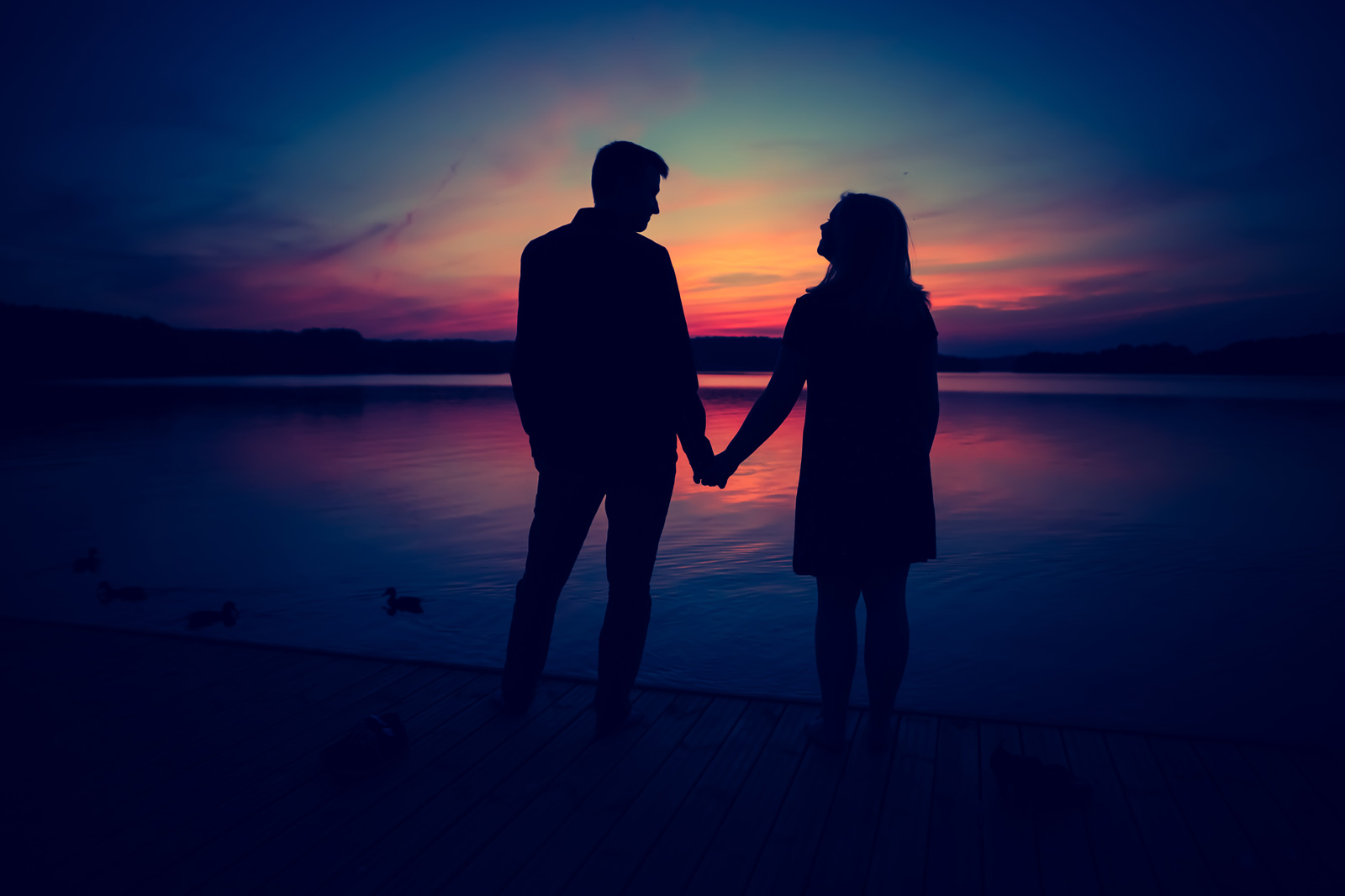 casal no por do sol e lago